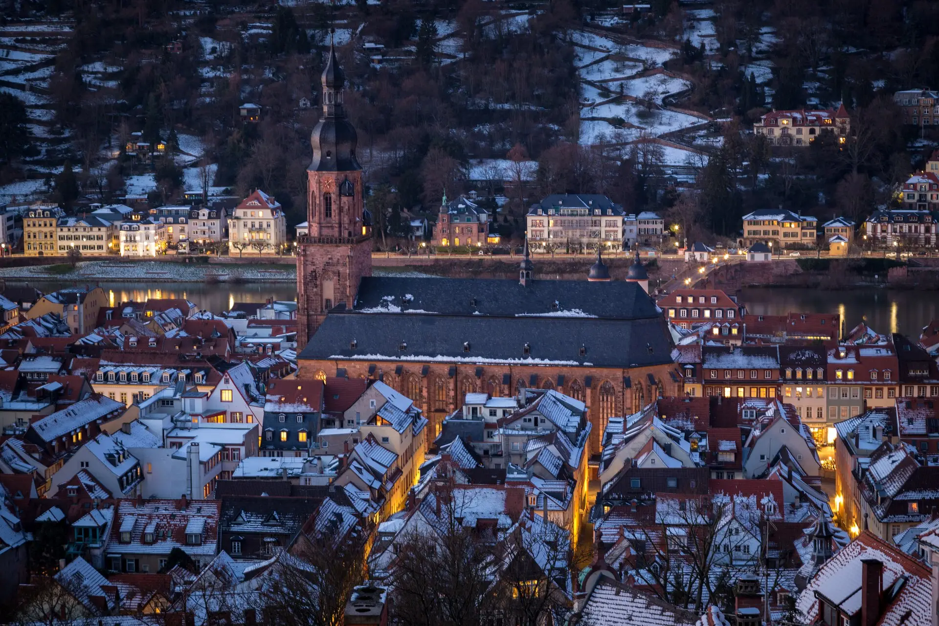Heiliggeistkirche und verschneite Dächer der Altstadt in einer Winternacht